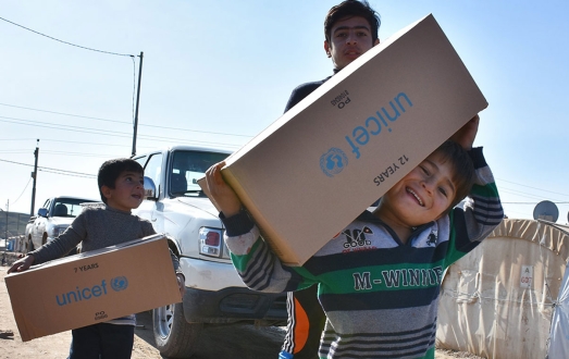 Chlildren with UNICEF aid boxes.
