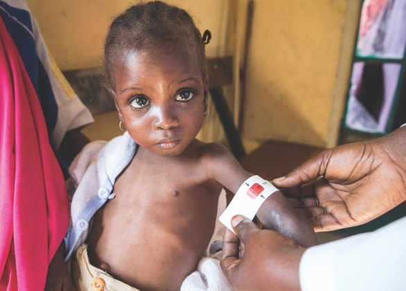 Child gets measured and weighed by charity staff at a UNICEF-assisted malnutrition treatment clinic in Maiduguri.