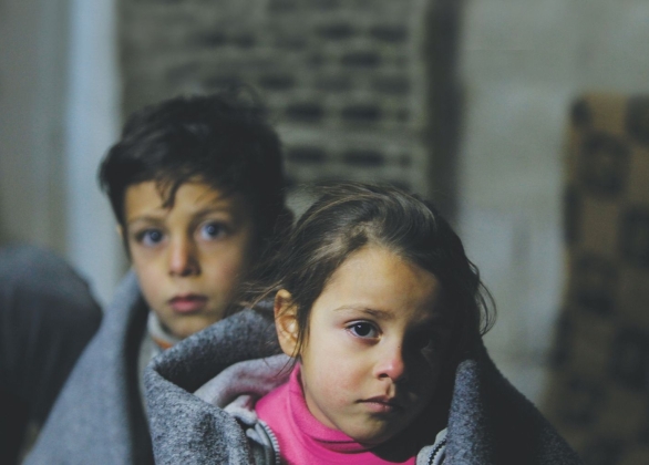 Deux enfants enveloppés dans des couvertures d’urgence