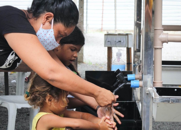 A woman and children use new handwashing facilities installed by UNICEF in Brazil.