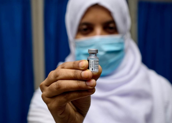 Un assistant à l’approvisionnement et à la logistique surveille la qualité des vaccins ROR (rou-geole, oreillons et rubéole) délivrés par l'UNICEF. 