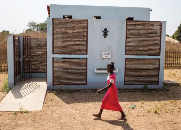 A student walks past toilets newly built by UNICEF at a primary school.