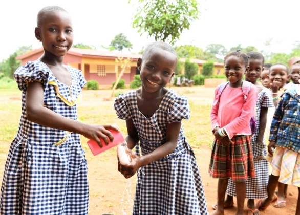 Girls wash their hands at a school.