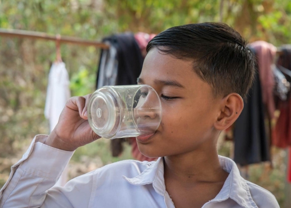 Un enfant tient un comprimé de purification de l'eau dans une main